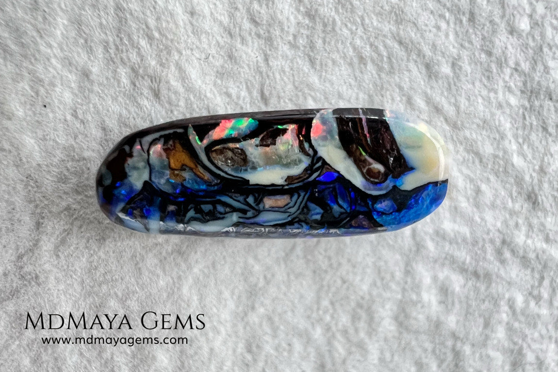 Koroit Boulder Opal 3.26 ct from Australia. Cabochon cut. Free form. I love the Koroit Opal with its intricate patterns, the precious opal embedded in the matrix fascinates me. In this case, the opal is the size of a pill with a very similar rounded shape,  and no matter which side you are looking at,  it is fascinating in any of them, its blue, red, green and lilac veins do not stop moving under the light. Just amazing.