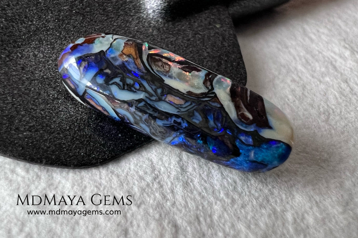 Koroit Boulder Opal 3.26 ct from Australia. Cabochon cut. Free form. I love the Koroit Opal with its intricate patterns, the precious opal embedded in the matrix fascinates me. In this case, the opal is the size of a pill with a very similar rounded shape,  and no matter which side you are looking at,  it is fascinating in any of them, its blue, red, green and lilac veins do not stop moving under the light. Just amazing.