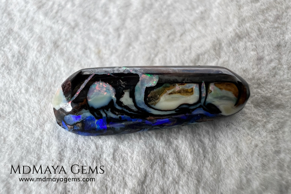 Koroit Boulder Opal 3.26 ct from Australia. Cabochon cut. Free form. I love the Koroit Opal with its intricate patterns, the precious opal embedded in the matrix fascinates me. In this case, the opal is the size of a pill with a very similar rounded shape,  and no matter which side you are looking at,  it is fascinating in any of them, its blue, red, green and lilac veins do not stop moving under the light. Just amazing.