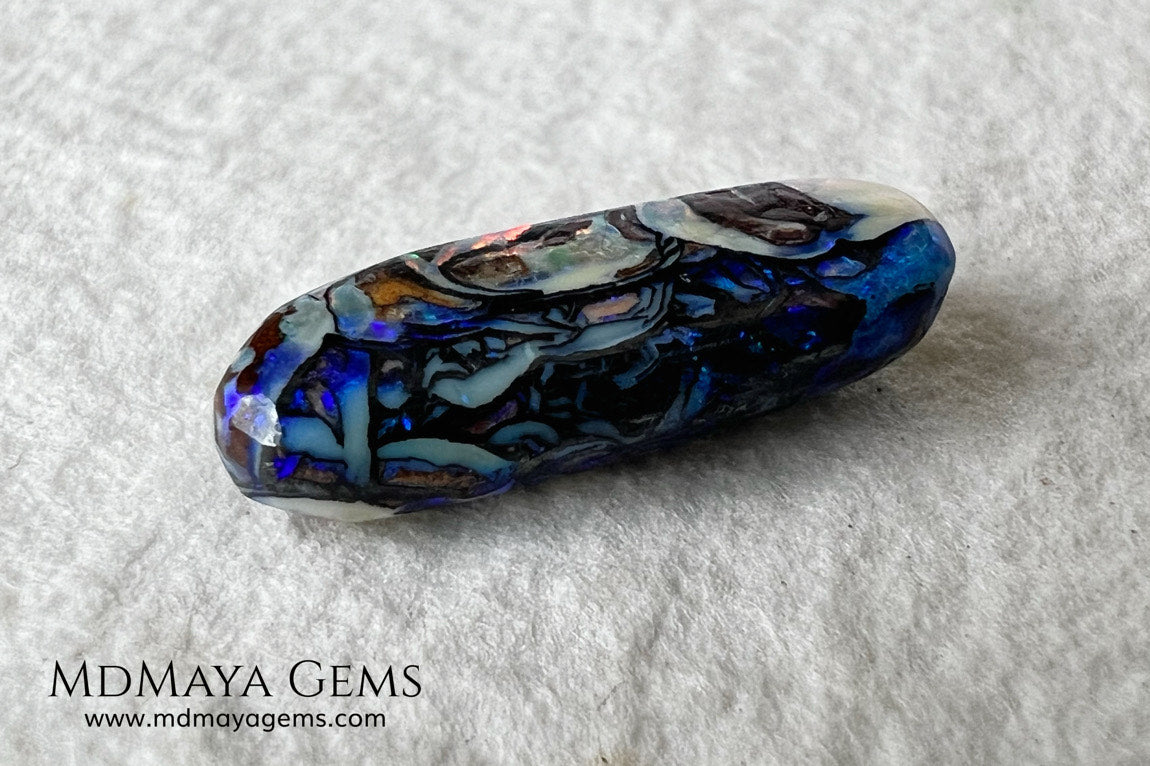 Koroit Boulder Opal 3.26 ct from Australia. Cabochon cut. Free form. I love the Koroit Opal with its intricate patterns, the precious opal embedded in the matrix fascinates me. In this case, the opal is the size of a pill with a very similar rounded shape,  and no matter which side you are looking at,  it is fascinating in any of them, its blue, red, green and lilac veins do not stop moving under the light. Just amazing.