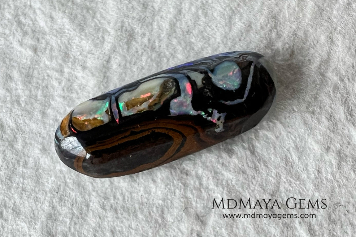Koroit Boulder Opal 3.26 ct from Australia. Cabochon cut. Free form. I love the Koroit Opal with its intricate patterns, the precious opal embedded in the matrix fascinates me. In this case, the opal is the size of a pill with a very similar rounded shape,  and no matter which side you are looking at,  it is fascinating in any of them, its blue, red, green and lilac veins do not stop moving under the light. Just amazing.