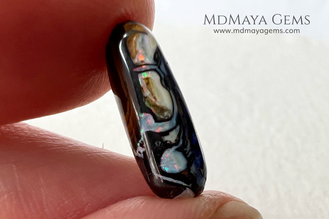 Koroit Boulder Opal 3.26 ct from Australia. Cabochon cut. Free form. I love the Koroit Opal with its intricate patterns, the precious opal embedded in the matrix fascinates me. In this case, the opal is the size of a pill with a very similar rounded shape,  and no matter which side you are looking at,  it is fascinating in any of them, its blue, red, green and lilac veins do not stop moving under the light. Just amazing.