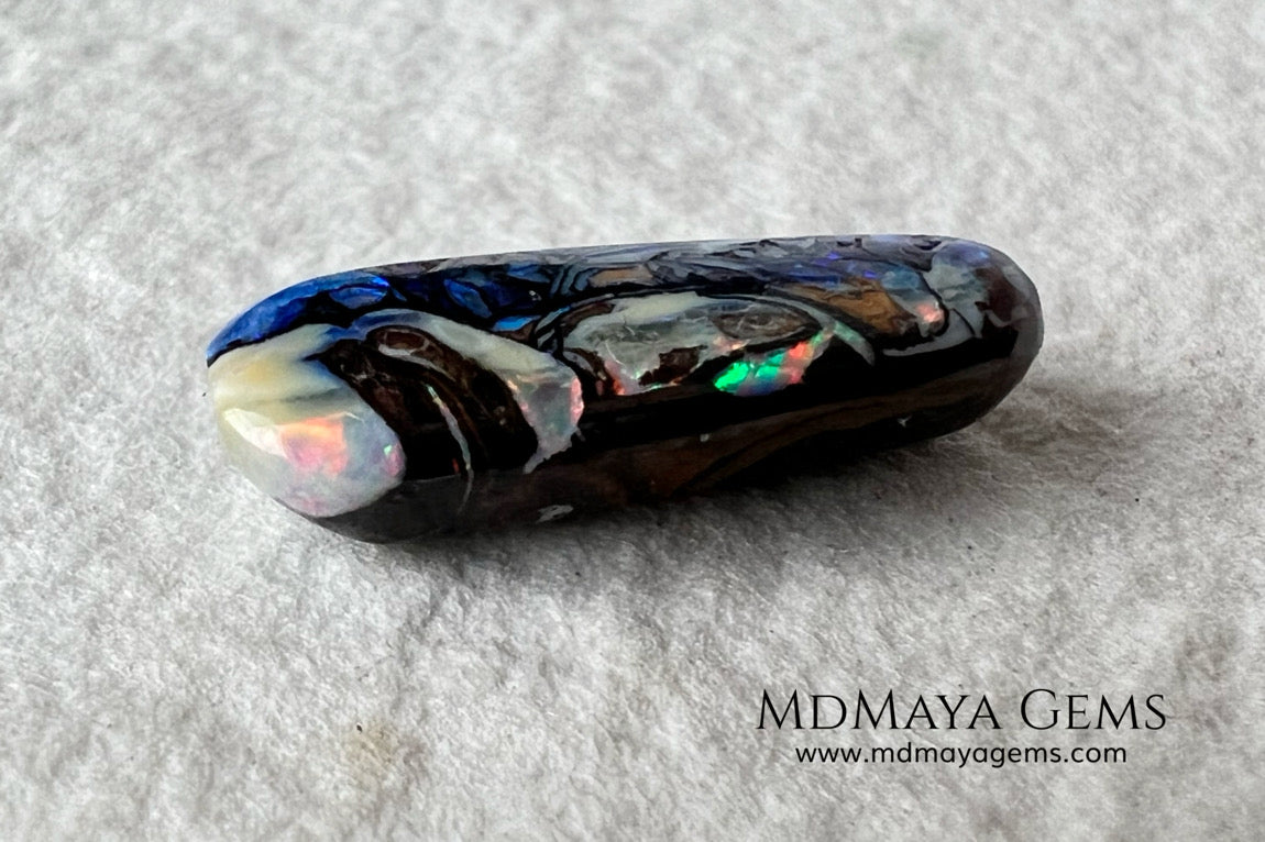 Koroit Boulder Opal 3.26 ct from Australia. Cabochon cut. Free form. I love the Koroit Opal with its intricate patterns, the precious opal embedded in the matrix fascinates me. In this case, the opal is the size of a pill with a very similar rounded shape,  and no matter which side you are looking at,  it is fascinating in any of them, its blue, red, green and lilac veins do not stop moving under the light. Just amazing.