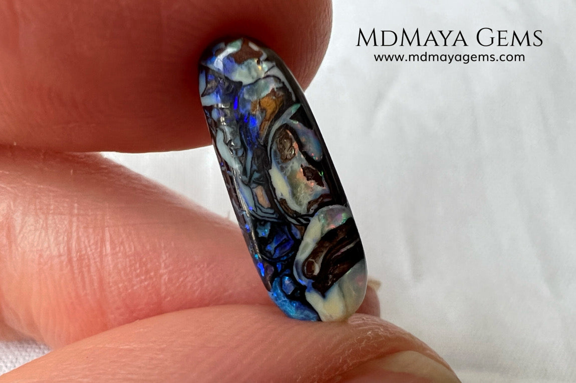 Koroit Boulder Opal 3.26 ct from Australia. Cabochon cut. Free form. I love the Koroit Opal with its intricate patterns, the precious opal embedded in the matrix fascinates me. In this case, the opal is the size of a pill with a very similar rounded shape,  and no matter which side you are looking at,  it is fascinating in any of them, its blue, red, green and lilac veins do not stop moving under the light. Just amazing.