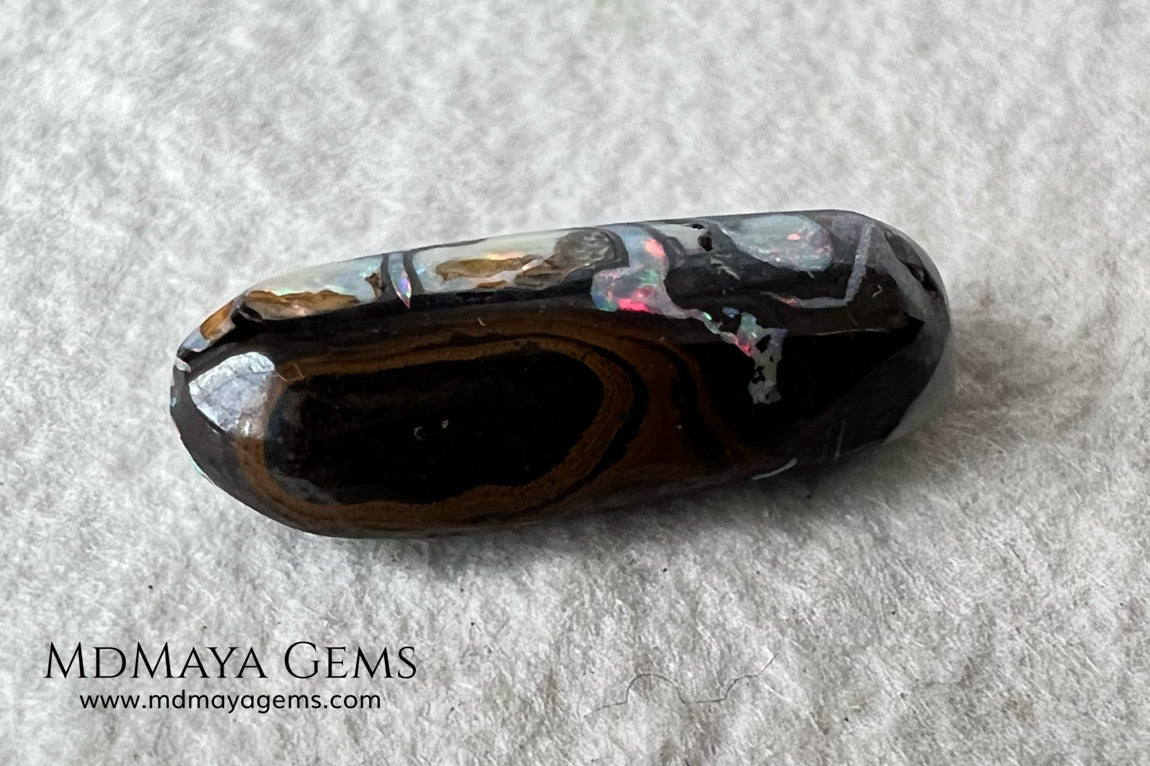 Koroit Boulder Opal 3.26 ct from Australia. Cabochon cut. Free form. I love the Koroit Opal with its intricate patterns, the precious opal embedded in the matrix fascinates me. In this case, the opal is the size of a pill with a very similar rounded shape,  and no matter which side you are looking at,  it is fascinating in any of them, its blue, red, green and lilac veins do not stop moving under the light. Just amazing.