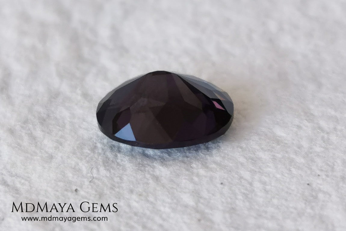 Dark Violet Spinel, 2.10 ct, oval cut. This dark gemstone has magnificent behavior under different light, under incandescent light, blue and purple sparkles are seen in it, making it very attractive. If you like different gems, you will like this one. Perfect for your custom jewelry.