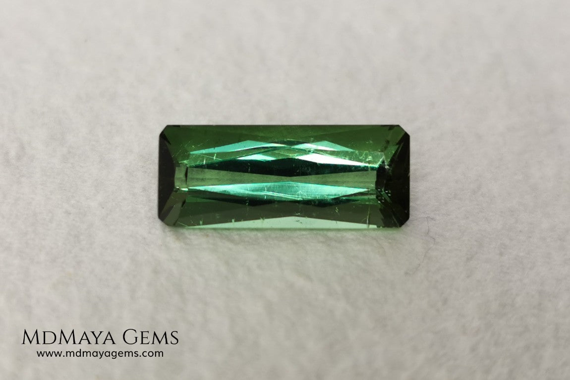 Green Tourmaline. 2.74 ct. Baguette cut. This elongated green stone shows a vivid and bright color. Its behavior under any type of light is marvelous, this pretty gem will look perfect in any kind of jewelry.