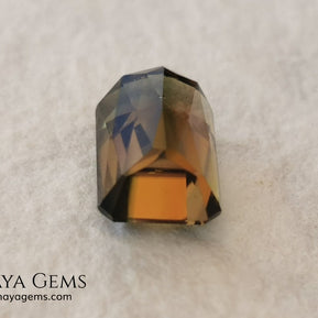 Bicolor Green Tourmaline 2.33 ct, emerald cut. This olive green bicolor tourmaline shows a orange - peach color depending on how the light falls on it. It has a good quality of cut and will look very beautiful in any piece of jewelry. A natural untreated gem at a low price.