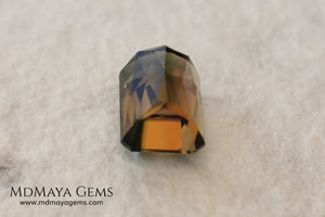Bicolor Green Tourmaline 2.33 ct, emerald cut. This olive green bicolor tourmaline shows a orange - peach color depending on how the light falls on it. It has a good quality of cut and will look very beautiful in any piece of jewelry. A natural untreated gem at a low price.