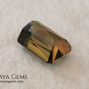 Bicolor Green Tourmaline 2.33 ct, emerald cut. This olive green bicolor tourmaline shows a orange - peach color depending on how the light falls on it. It has a good quality of cut and will look very beautiful in any piece of jewelry. A natural untreated gem at a low price.