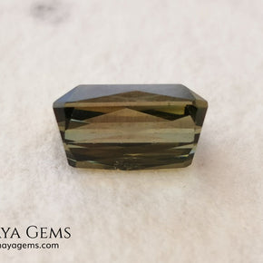 Bicolor Green Tourmaline 2.33 ct, emerald cut. This olive green bicolor tourmaline shows a orange - peach color depending on how the light falls on it. It has a good quality of cut and will look very beautiful in any piece of jewelry. A natural untreated gem at a low price.