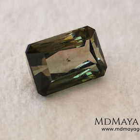 Bicolor Green Tourmaline 2.33 ct, emerald cut. This olive green bicolor tourmaline shows a orange - peach color depending on how the light falls on it. It has a good quality of cut and will look very beautiful in any piece of jewelry. A natural untreated gem at a low price.