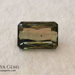 Bicolor Green Tourmaline 2.33 ct, emerald cut. This olive green bicolor tourmaline shows a orange - peach color depending on how the light falls on it. It has a good quality of cut and will look very beautiful in any piece of jewelry. A natural untreated gem at a low price.