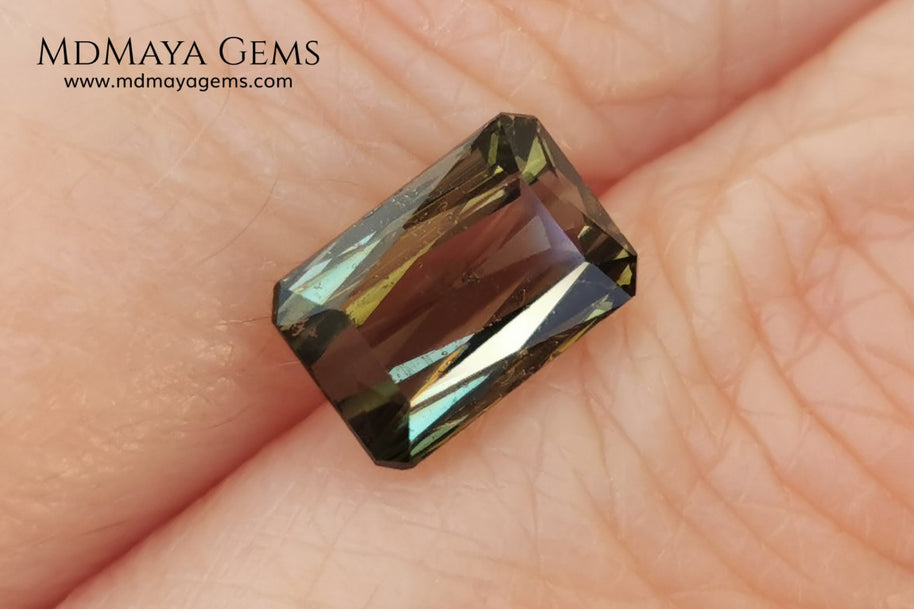Bicolor Green Tourmaline 2.33 ct, emerald cut. This olive green bicolor tourmaline shows a orange - peach color depending on how the light falls on it. It has a good quality of cut and will look very beautiful in any piece of jewelry. A natural untreated gem at a low price.
