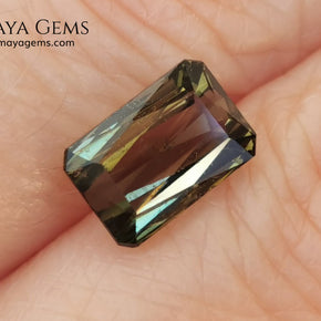 Bicolor Green Tourmaline 2.33 ct, emerald cut. This olive green bicolor tourmaline shows a orange - peach color depending on how the light falls on it. It has a good quality of cut and will look very beautiful in any piece of jewelry. A natural untreated gem at a low price.