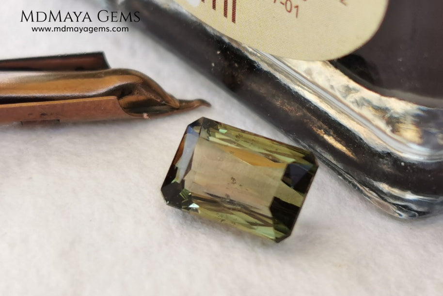 Bicolor Green Tourmaline 2.33 ct, emerald cut. This olive green bicolor tourmaline shows a orange - peach color depending on how the light falls on it. It has a good quality of cut and will look very beautiful in any piece of jewelry. A natural untreated gem at a low price.
