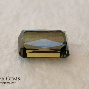 Bicolor Green Tourmaline 2.33 ct, emerald cut. This olive green bicolor tourmaline shows a orange - peach color depending on how the light falls on it. It has a good quality of cut and will look very beautiful in any piece of jewelry. A natural untreated gem at a low price.