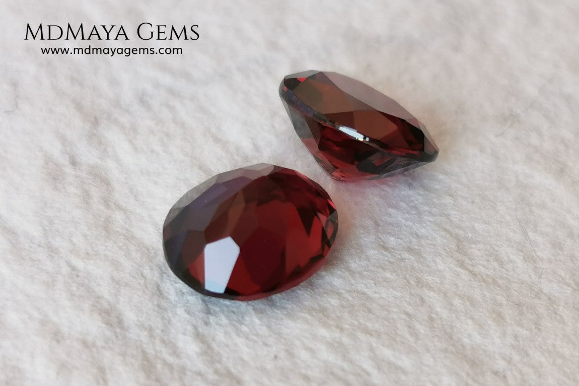 Dark Red Rhodolite Pair, 5.24 ct, oval cut. This beautiful pair of rhodolites shows a dark red color, although it is full of life and sparkles. It has a very good size and they will look incredibly beautiful on some earrings or on a pair of cufflinks.