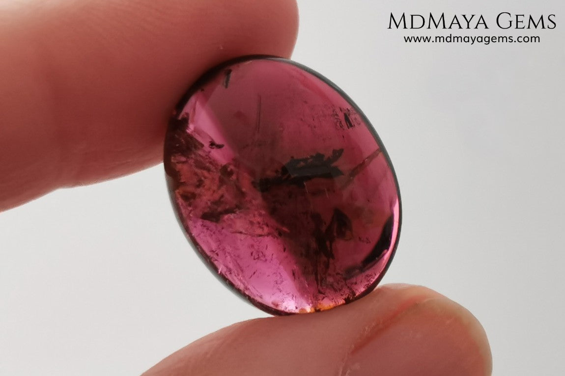 Large tourmaline rubellite, 16.08 ct, oval cabochon cut. This beautiful natural gem features two shades of color, one darker than the other. Although it has inclusions, it will be beautiful once mounted on any piece of jewelry you can imagine. And the best its price. $15 per carat.