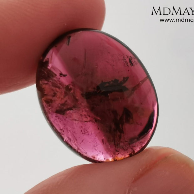 Large tourmaline rubellite, 16.08 ct, oval cabochon cut. This beautiful natural gem features two shades of color, one darker than the other. Although it has inclusions, it will be beautiful once mounted on any piece of jewelry you can imagine. And the best its price. $15 per carat.