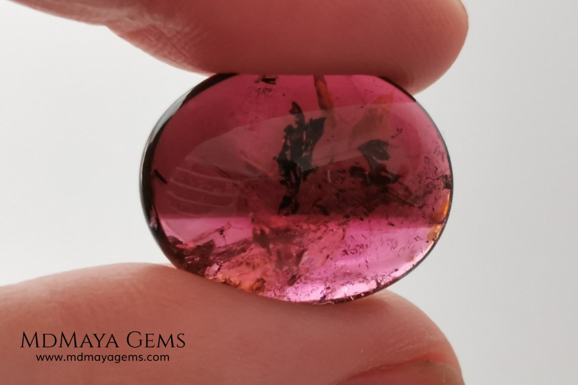 Large tourmaline rubellite, 16.08 ct, oval cabochon cut. This beautiful natural gem features two shades of color, one darker than the other. Although it has inclusions, it will be beautiful once mounted on any piece of jewelry you can imagine. And the best its price. $15 per carat.